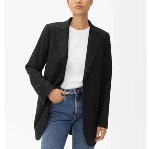 Scallop Blazer från Arket - Snygg kavaj från Arket med scalloped kanter. Den har två fickor framtill och en innerficka. Kavajen är i en rak passform och har en något längre längd.  Endast använd ett fåtal gånger, i mycket gott skick.   Storlek: 34