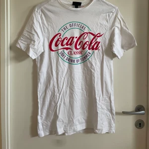 Coca-Cola tröja - En vit T-shirt med Coca-Cola tryck, knappt använd.
