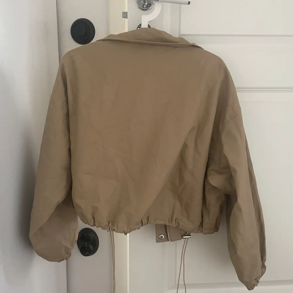 En beige jacka från Gina tricot. Aldrig använd och säljs inte längre. Den har jätte många fina detaljer och är en perfekt sommar och höst jacka!. Jackor.