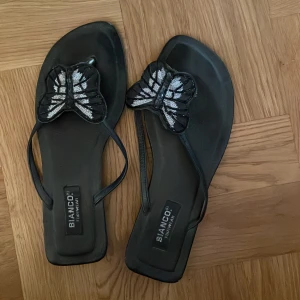 Fjärilssandaler - Söta flipflopsliknande sandaler🦋står ingen storlek på men passar mig som har stl 39/40. De är i använt skick. säljs billigt då de inte kommer till användning och jag vill bli av med dem så snabbt som möjligt☺️ skriv gärna om du har några frågor💗