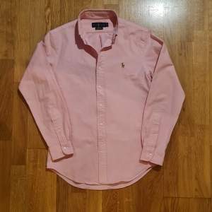 Säljer denna rosa oxfordskjorta från Ralph Lauren. Storlek small slim fit. Stretch oxford material Väldigt bra skick, nyskick skulle jag säga. Hör av dig för frågor eller funderingar