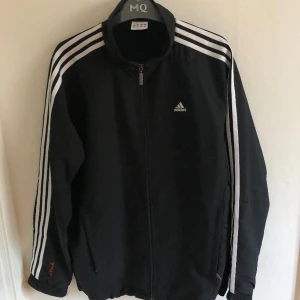 Adidas vindjacka stl M - Jag säljer en svart Adidas vindjacka i bra skick utan defekter. Jackan är i storlek M. Skriv gärna vid eventuella frågor:)