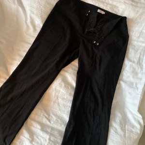 Svarta lågmidjade kostymbyxor - Säljer dessa kostymbyxor då dem inte kommer till användning. Jätte fina med snyggt knäppe och fin passform längst ner. 