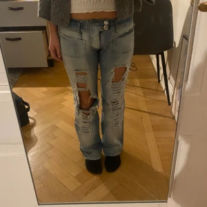 Lågmidjade jeans - Säljer dessa jättesnygga lågmidjade jeans med revor då de tyvär är lite små på mig. De har ett litet hål över fickan men verkligen inget man tänker på (se bild 3). Passar någon som är typ 163 
