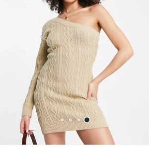 Beige stickad klänning - Beige stickad klänning one shoulder. Aldrig använd och figurformad. Skriv för fler bilder