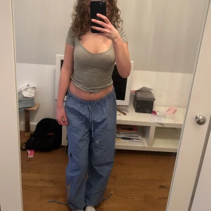 randiga byxor  - säljer dessa byxor jag köpte i barcelona, blåa med mörkblåa ränder, framfickor, sidofickor samt en ficka där bak, är 175 och de är långa på mig 