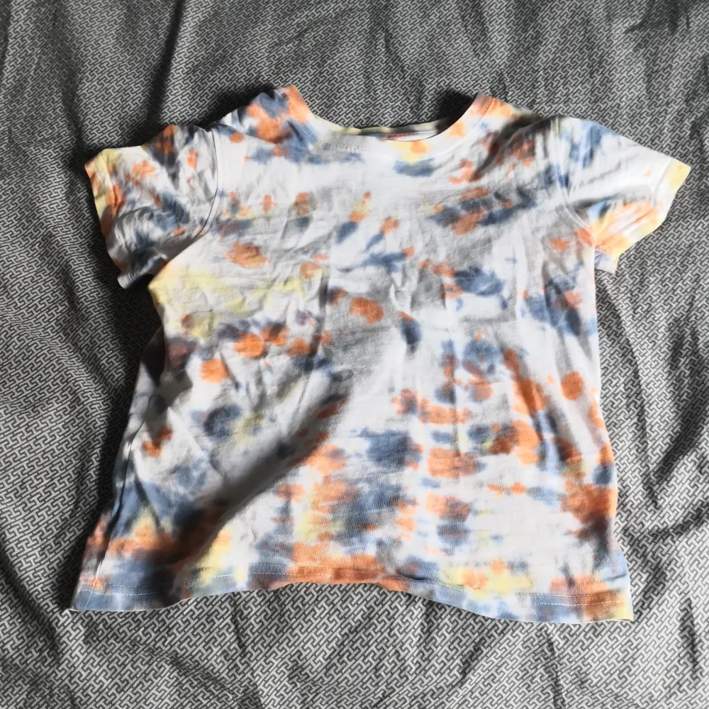 Fin tie dye t-shirt med färgerna orange, gul och blå/lila. T-shirten har 3 små hål där bak. Annars bra skick. Skriv för flera bilder🤍. T-shirts.