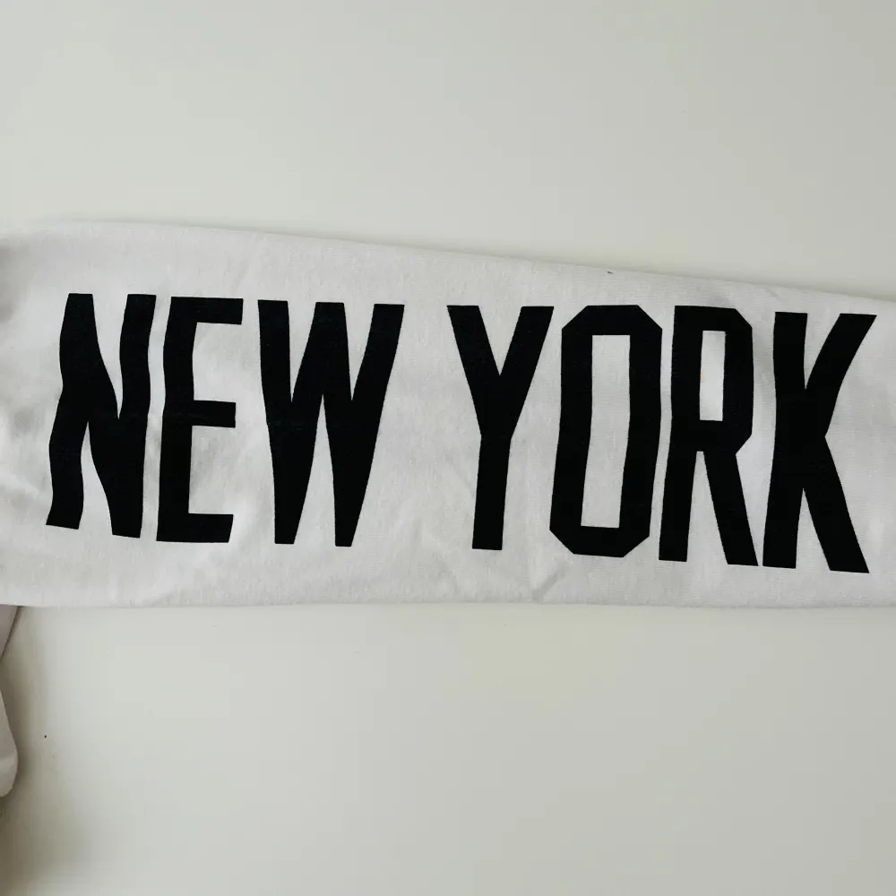 Det är en vit hoodie som är en magtröja och så står det ”NEW YORK” på båda armarna. Har aldrig🙌 använt den. Stryks innan leverans❤️. Hoodies.