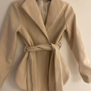 Beige kappa - En jätte fin beige kappa köpt secondhand som har aldrig använts då den sitter för liten på mig