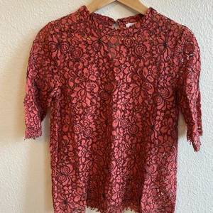 Spetstopp, storlek 36 - Mörk organge/röd topp i spets med blommönster, storlek 36 från Kaffe. 