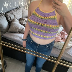 Handgjord virkad topp i pastellfärger  - Toppen har små blommor på och genom att man kan justera banden bak för storlek passar den XS-M.