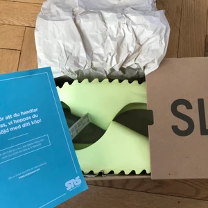 Yeezy slide glow green - Yeezy slide glow green från sneakersnstuff har inte kvar kvittot då jag var smart nog att slarva bort det när jag städade mitt rum men kan skicka meddelanden och mails från sns på dms.