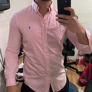 Ralph Lauren Polo skjorta, rosa randig köpt i New York. Välanvänd. Storlek S, slim fit. Ganska stor i storlek dock.