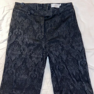 Svarta kostymbyxor  - Ett par superfint mönstrade svarta konstymbyxor från hennes collection. Hade gärna behållt dom själv men dessvärre blivit för små för mig. Skulle säga att de sitter lågt/medel och med rak modell. Går ner till golvet med skor på. (Är ca 160 cm lång) 