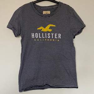 Nästintill helt oanvänd T-shirt från Hollister i storlek S, vit/mörkblåa ränder! Skriv för fler bilder💕
