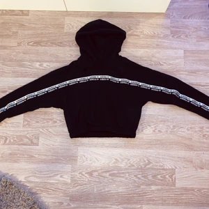 Adidas kort Hoodie - En lite kortare Adidas Hoodie, slutar precis under naveln, sitter snyggt till ett par jeans eller till mjukisar. Mysig och snygg, säljer för jobbar på adidas och måstw rensa ut alla mina adidas kläder. Använd ca 3 ggr bara. Väldigt stor i storleken, är i storlek 42 men passar en 36a/38a. Frakt ingår ej i priset. 