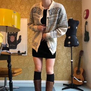 Stickad tröja  - En stickad cardigan med grå/blått mönster, metalknappar. 