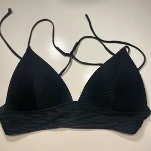 Trendig svart triangelformad bikiniöverdel från HM! ☺️ storlek 38 men går somsagt att ställa in, knyts ihop bak och går att ställa in banden, aldrig använd 😻 frakt tillkommer