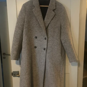 Filippa K kappa  - Grå kappa från Filippa K. Bra skick, inget att anmärka på. Säljer pga lite för stor för mig. Frakt tillkommer. 