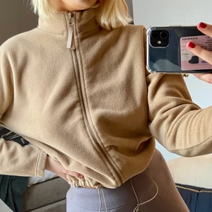 Fleece - En söt fleece från Gina Tricot. Kortare i modellen och går att justera i nedre kanten på tröjan. Beige med hög krage om helt uppdragen! Supermysig i vinter!! XS men passar mig med S