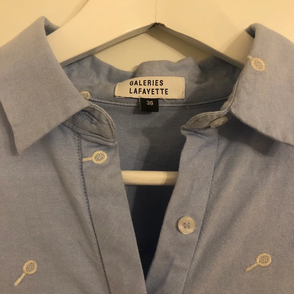 Så fin skjorta från Galeries Lafayette som tyvärr inte kommit till användning mycket alls. Nypris ca 800. I nyskick! Jättefina detaljer i ärm. Broderade små ”tennisrack”. Fin att styla till både jeans eller kostymbrallor 💙. Skjortor.