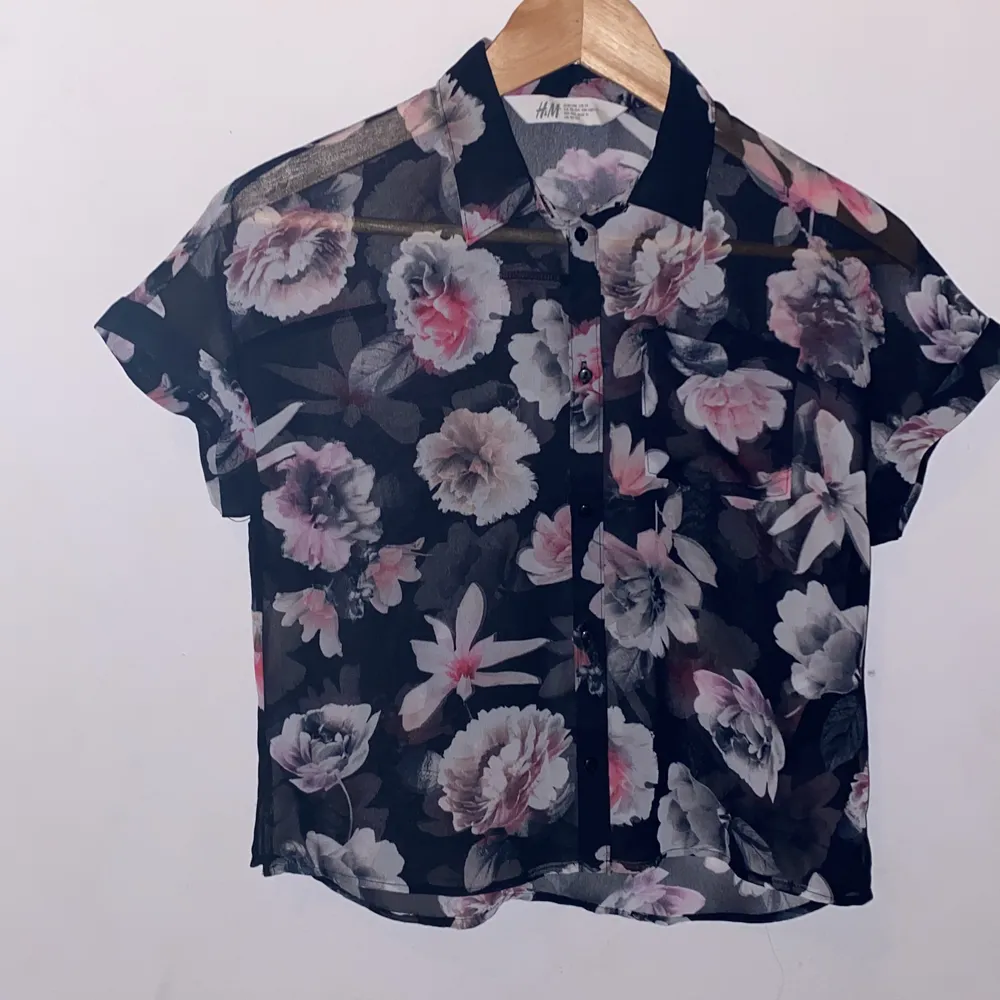 Den är blommig men det är en tröja men den är jätte jag kan se under man ska ha en tröja under med de färgerna är rosa vit lila och svart . T-shirts.