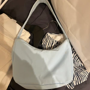 Gina tricot - Blå väska köpt från Gina, kommer ej ihåg priset på den men skulle gissa på 250kr kanske, är en fläck under av mat, köpt för nått år sedan, går säkert att få bort fläcken har ej provat