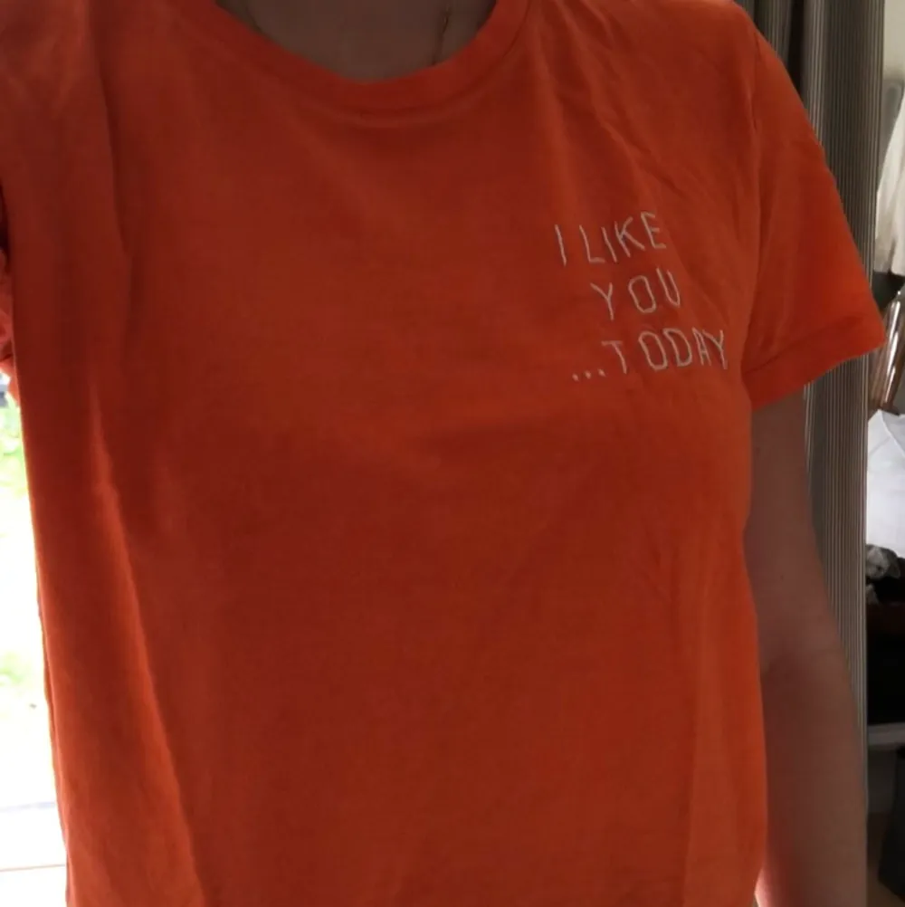 Orange t-shirt. Broderad text. T-shirts.