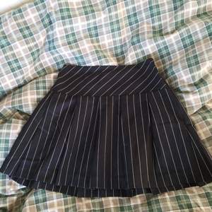 En pleated skirt svart färg med vita sträck/linger. High/mid waist kjol från h&m. Aldrig använts men säljs då den är för liten och pris lapparna har rivits av så jag kan ej återlämna. orginalpris - 200kr
