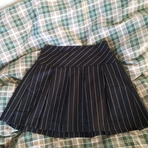pleated svart high waist kjol  - En pleated skirt svart färg med vita sträck/linger. High/mid waist kjol från h&m. Aldrig använts men säljs då den är för liten och pris lapparna har rivits av så jag kan ej återlämna. orginalpris - 200kr