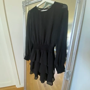 Svart volangklänning - En svart volangklänning från Ginatricot i storlek 34 (XS). 