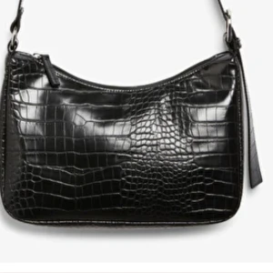 Svart axelväska  - Använt ett fåtal gånger men ändå ett bra skick. Dock inte som ny då den tappat lite färg på sidan av dragkedjan. Dock syns det inte från håll men på nära titt. Fin till färgglada toppar! Väskan kommer från monki och är en den nyare modellen. Köparen står för frakten och kan diskuteras privat. 