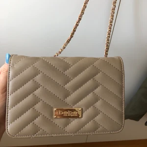Bebe axelväska - Bebe axelväska från USA. Använd ca 3 gånger & har en liten slitning i bandet. Går att använda som en axelväska & som en crossbody väska.