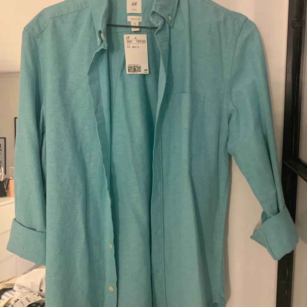 Superfin skjorta från HM i fin turkos färg. Aldrig använd med lapp kvar. Köparen står för frakten.. Skjortor.