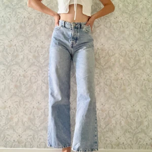 Bikbok Jeans stl 24 / S - *Vida och raka jeans *Knappar och liknande detaljer i silver. *Från bikbok. *Är i storlek 26 i midjan. *2 rymliga fickor fram och bak. *Stängs med knappar, ej dragkedja. *Priset är ex. frakt 96kr. *Säljer eftersom att de är för stora i midjan för mig. *De är nästan aldrig använda av mig pga problemet med storleken men annars assnygg modell.  *Alla bilder är privata.  *Skicka dm vid frågor eller mer bilder💕