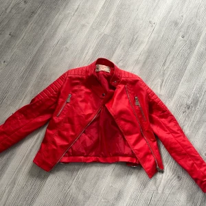 Röd skinnjacka  - Storlek 38, tight i armarna. Använd ett fåtal gånger pga för tight i armarna 