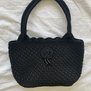 Svart virkad väska!  - Världens sötaste virkade väska! Den är svart och har detaljer med svarta pärlor på, perfekt att ha på axeln men är snäppet större än den klassiska baguettväskan! Den är köpt secondhand men ser knappt andvänd ut! Den har dragkedja för att stänga samt ett innerfack med dragkedja! 