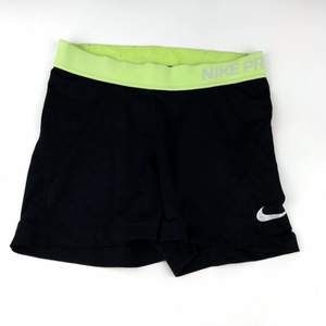 Snygga svarta Nike PRO shorts med gul/gröna detaljer. Super snygga och i bra skick men har tyvärr blivit för små. Frakt ingår i priset
