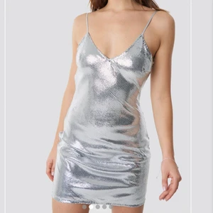 Silvrig paljettklänning designad av Linn Ahlborg - Jättefin paljettklänning från Linn Ahlborg x na-kd som numera är slutsåld. Säljs på grund av att den tyvärr aldrig kommer till användning längre. Den är använd en gång så nyskick och förtjänar mer kärlek än så! Nypris: 499kr