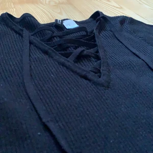 Svart topp med band därframme  - Fin svart ribbad topp med band därframme ✨ Passar till både kjol och byxor, både finklätt som till vardags💛 Finns inga hål eller färgmissbildningar 🍀 