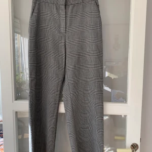 Rutiga byxor H&M - Byxor från H&M. 55% polyester, 44% ull och 1% elastan. Stl 38.