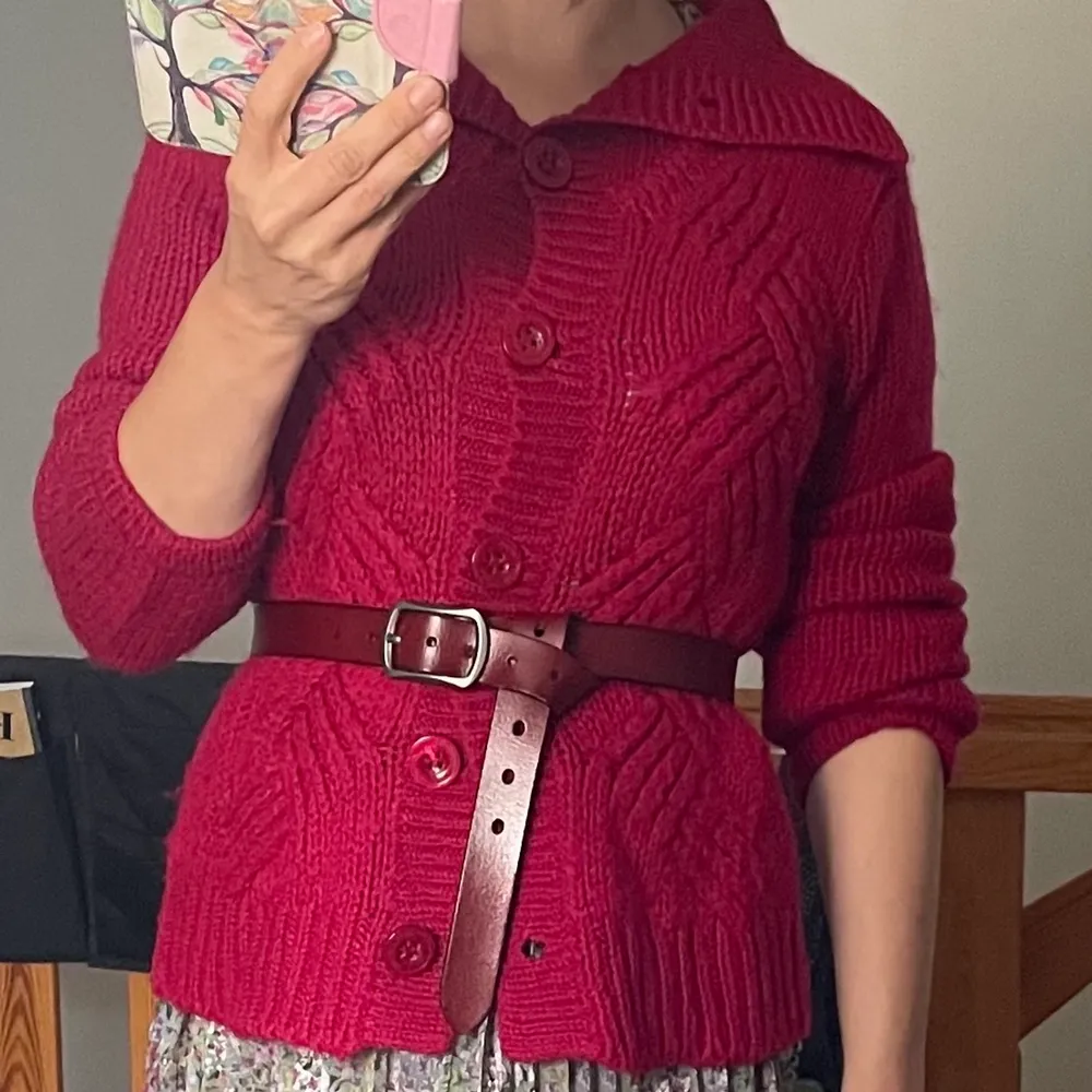 En mjuk och varm cardigan i vacker röd nyans i ullblandning. Längden 63 cm. 40 % ull. Neuleet.