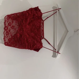 Fest top i röd spets! - Fest topp i jätte fint skick då den aldrig använts! Köpt för 200 har jag för mig så säljer den för 89 kr plus frakten såklart. Kan mötas upp i närheten av Ludvika där jag bor!