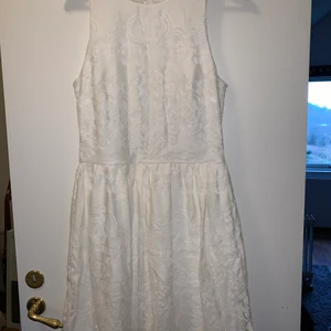 Vit klänning Stl 42 - Superfin klänning med lite öppen rygg, oanvänd med lappen kvar. Yttre lager av spets.