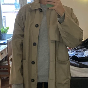Trenchcoat Monki  - Trenchcoat från Monki. Nästintill oanvänd. Storleken S. Av någon anledning kan jag inte visa hela kappan men dm:a för mer bilder. Jag är 167 och kappan går till halva vaden på mig. Möter helst upp i närheten av Södermalm men kan också frakta (köparen står för frakten) 