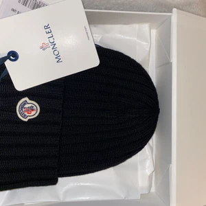 Moncler mössa  - Denna svarta moncler mössan köpte jag för två veckor sen men vet tyvärr att den inte kommer komma till nån användning. Den är aldrig använd. Helt ny, har kvitto till och prislappen sitter kvar.
