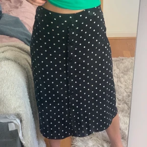 Svart prickig kjol - En svart kjol med vita prickar, men knappar i mitten. Jättefin men kommer inte till användning. Skönt material som är lite tjockare.