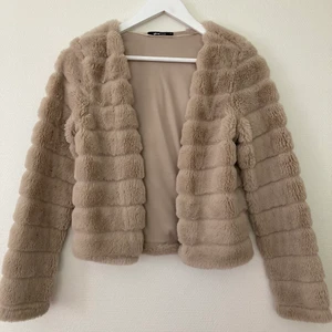 Fluff jacka - En beige fluff jacka