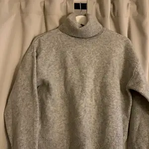 En tjock polo stickad tröja i grå