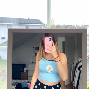 Topp med blomma  - Söt sommar-topp med blomma, stretchigt material, aldrig använd. Storlek S/M.